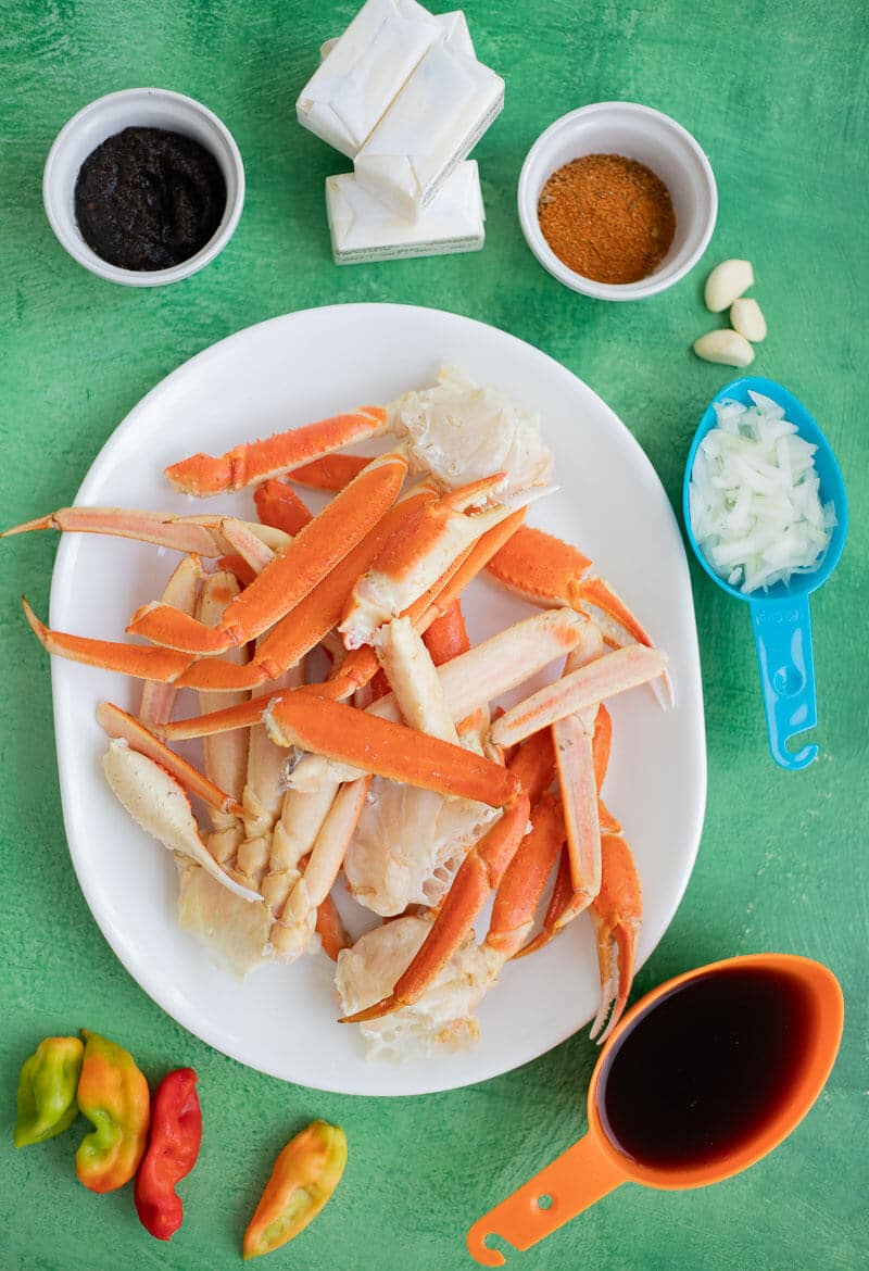 Ingredients including snow crab, butter, jerk seasoning, garlic, onion, pimento peppers, and stock.