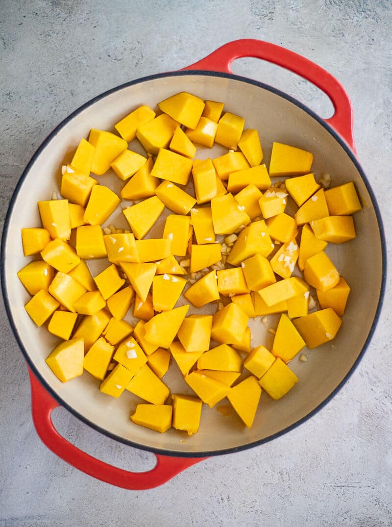 Cubed pumpkin and garlic in a pot for pumpkin choka.