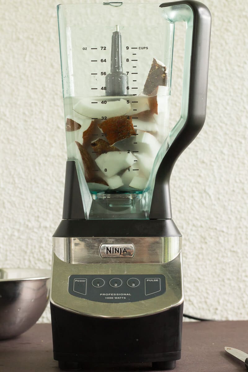 An easy step by step guide for making coconut milk from a fresh dry coconut just like we do it in the Caribbean. Fresh coconut pieces and water blended to make homemade coconut milk.