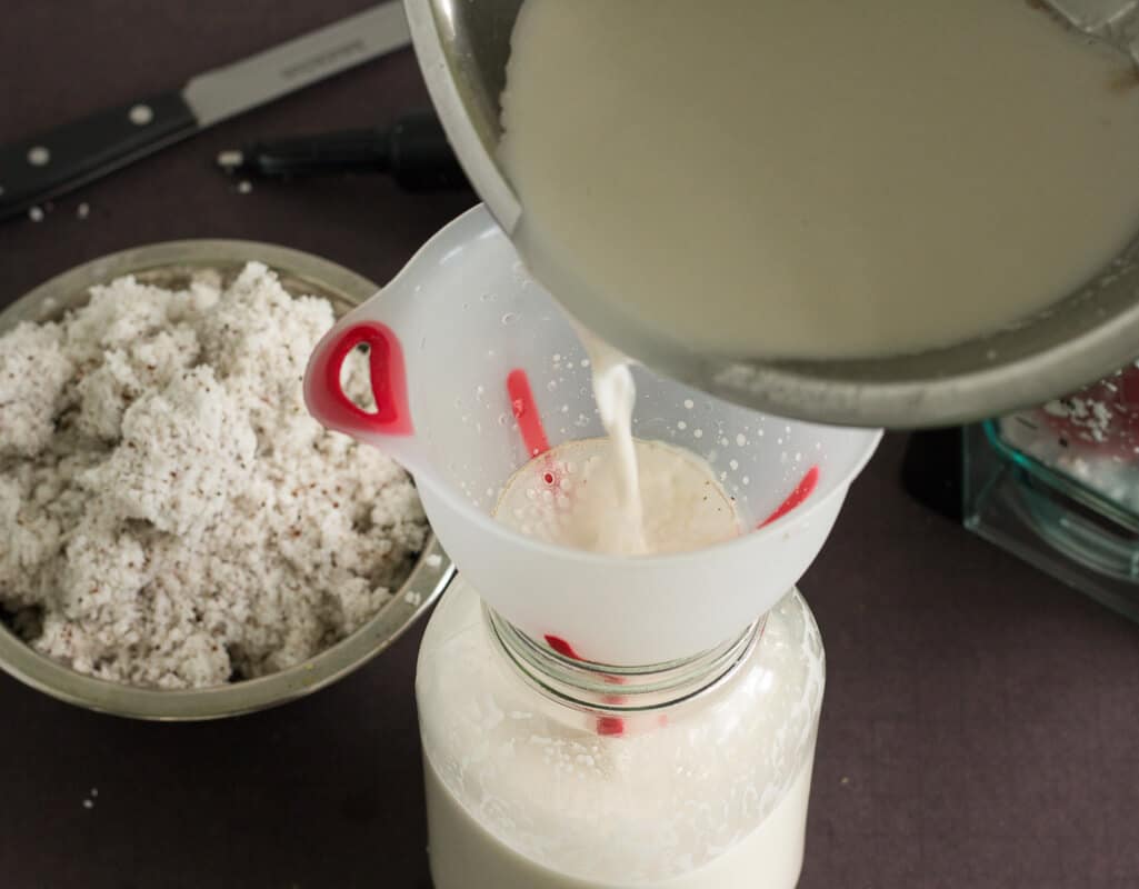 Pouring coconut milk into glass jar.