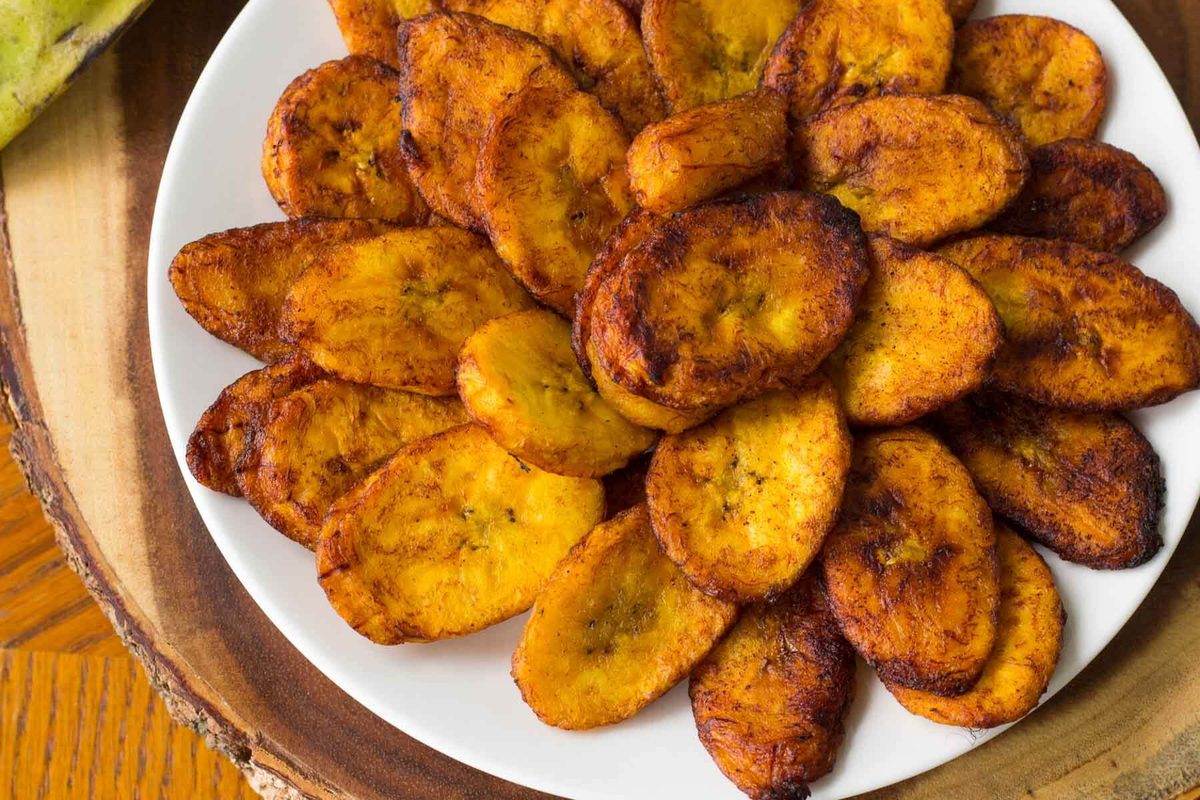 Discover the perfect blend of sweet and spicy in our easy spicy fried plantains recipe—an irresistible twist on a Caribbean and African favorite! Spicy fried ripe plantain slices served on a white plate