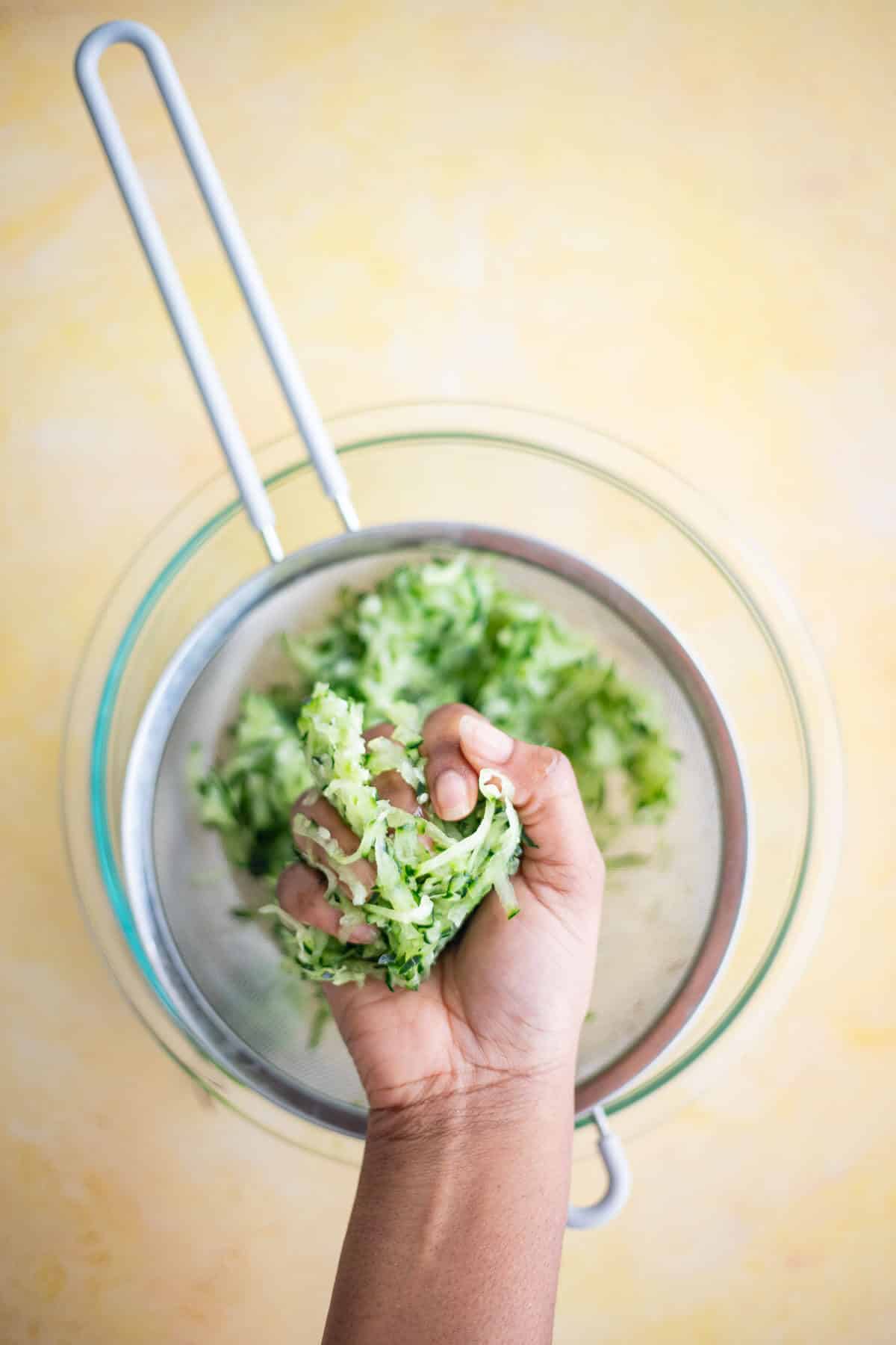 Squeezing excess liquid from grated cucumber