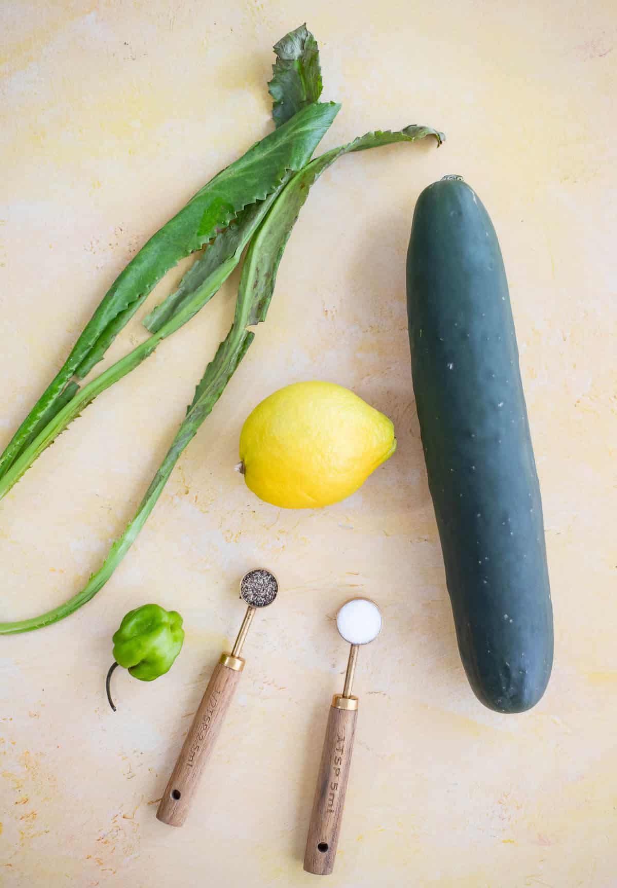 Ingredients for Trinidad cucumber chutney including cucumber, chadon beni, lemon and Scotch bonnet pepper