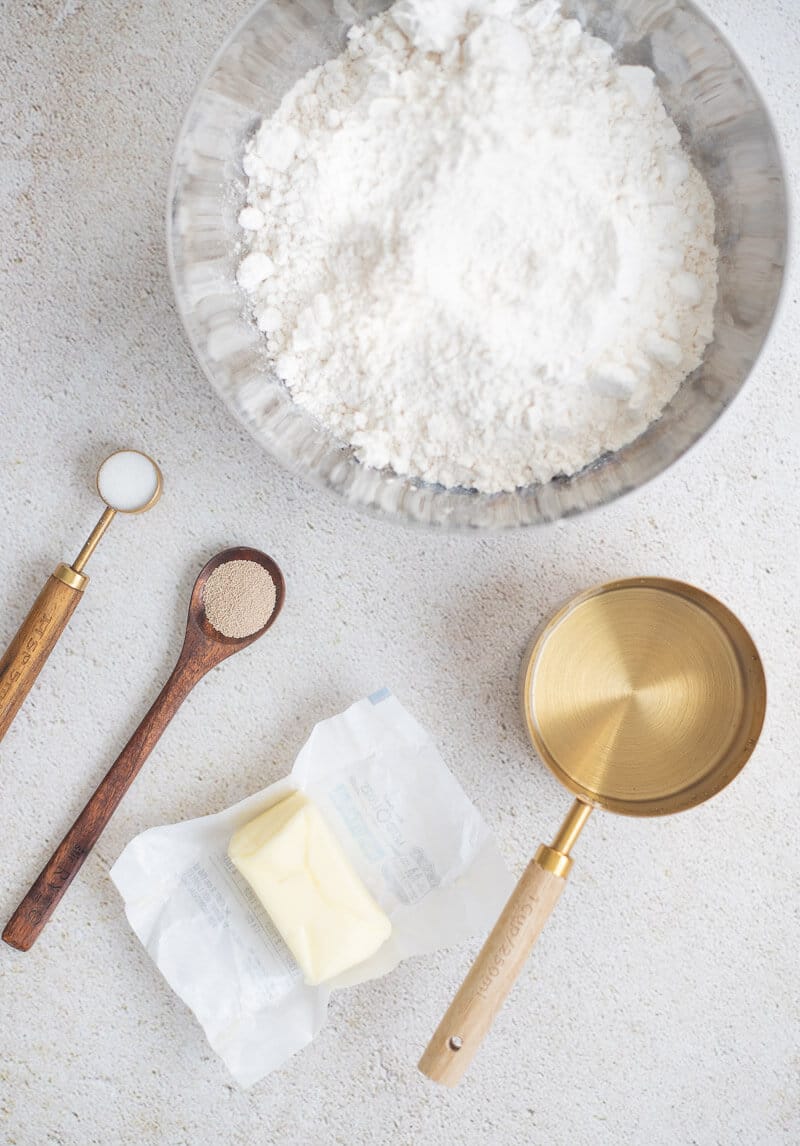 Ingredients for making Jamaican hard dough bread including flour, yeast, butter, sugar, and water.