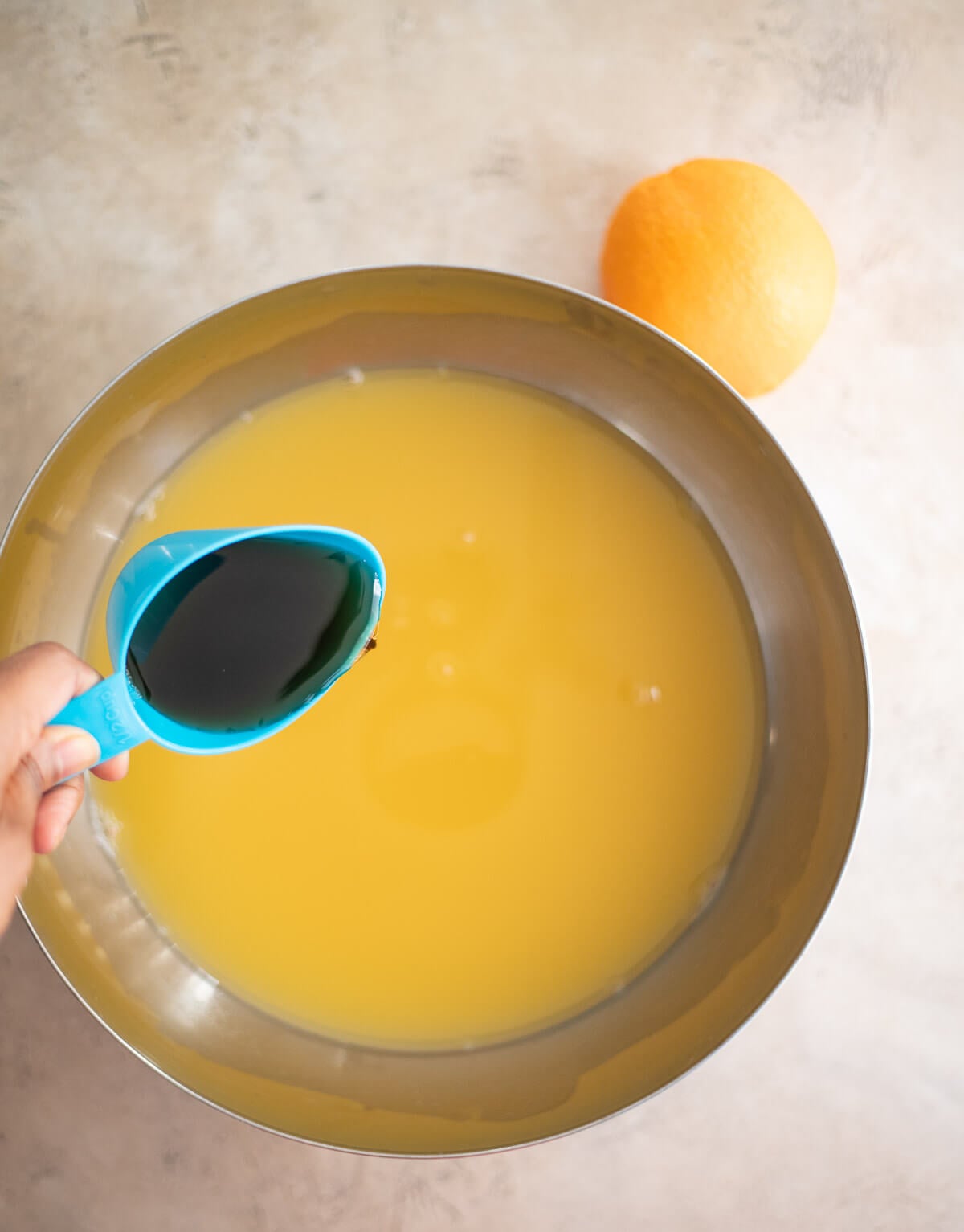 Pouring Demerara syrup into the fruit juice and rum mixture for Le Planteur.