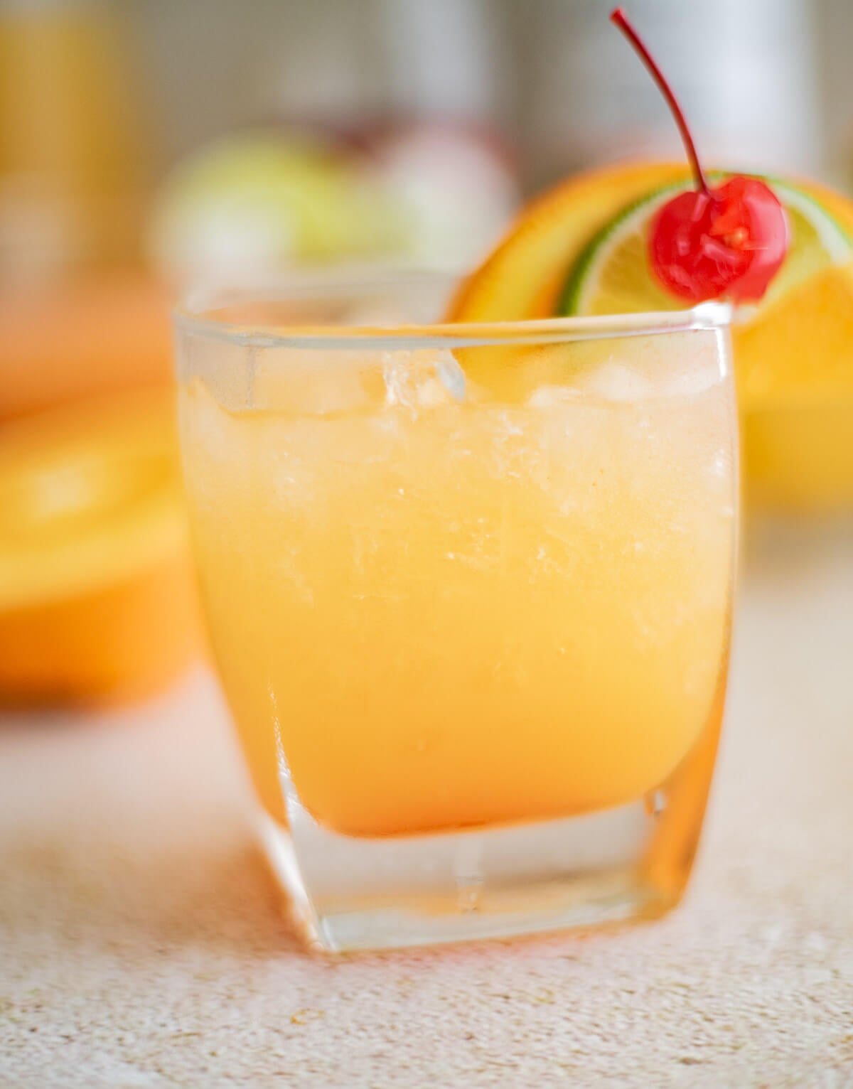 Le Planteur rum punch served over ice with orange, lime, and cherry garnish.