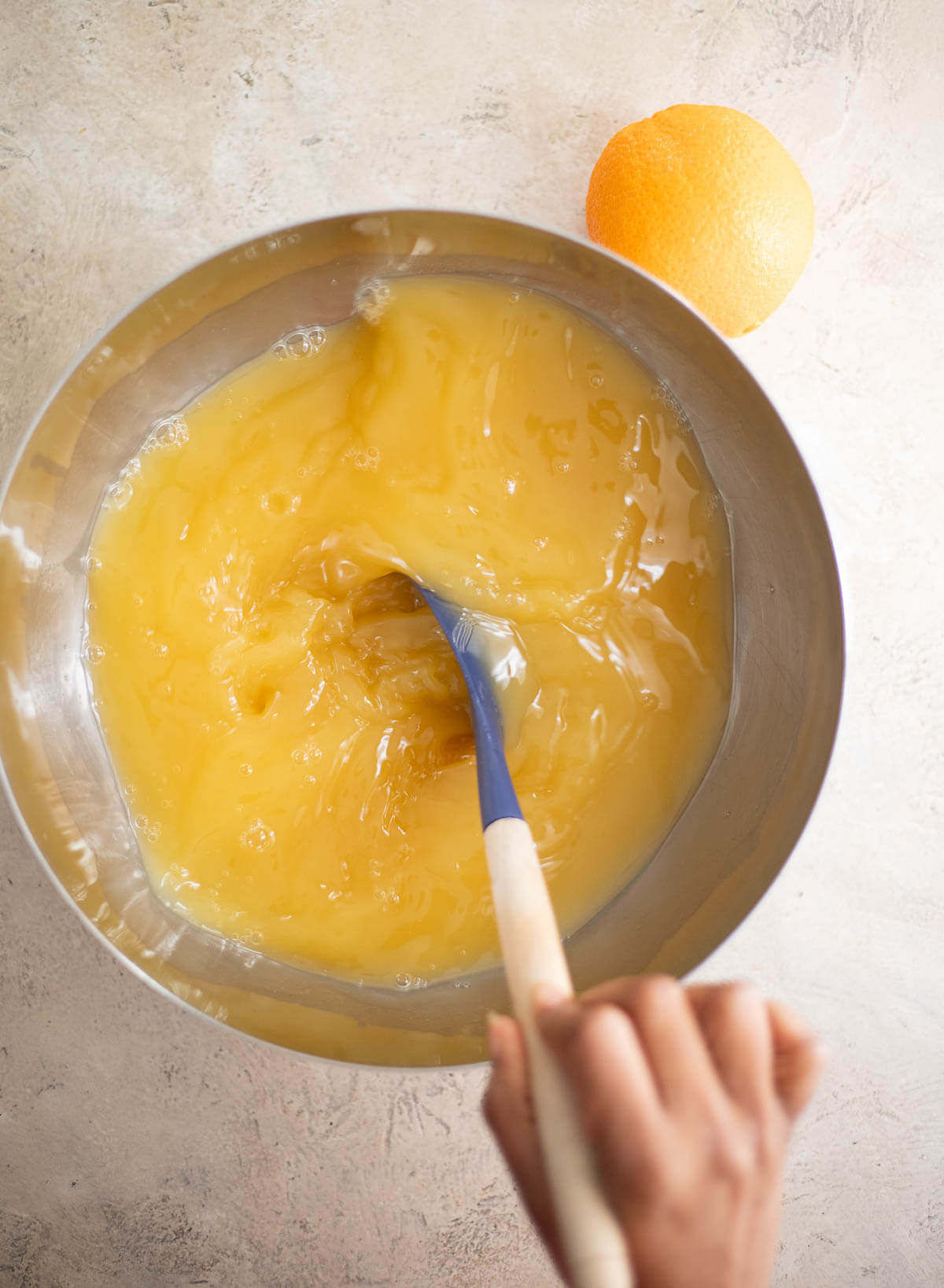 Stirring the fruit juices, rum, and syrup together to make Le Planteur cocktail.