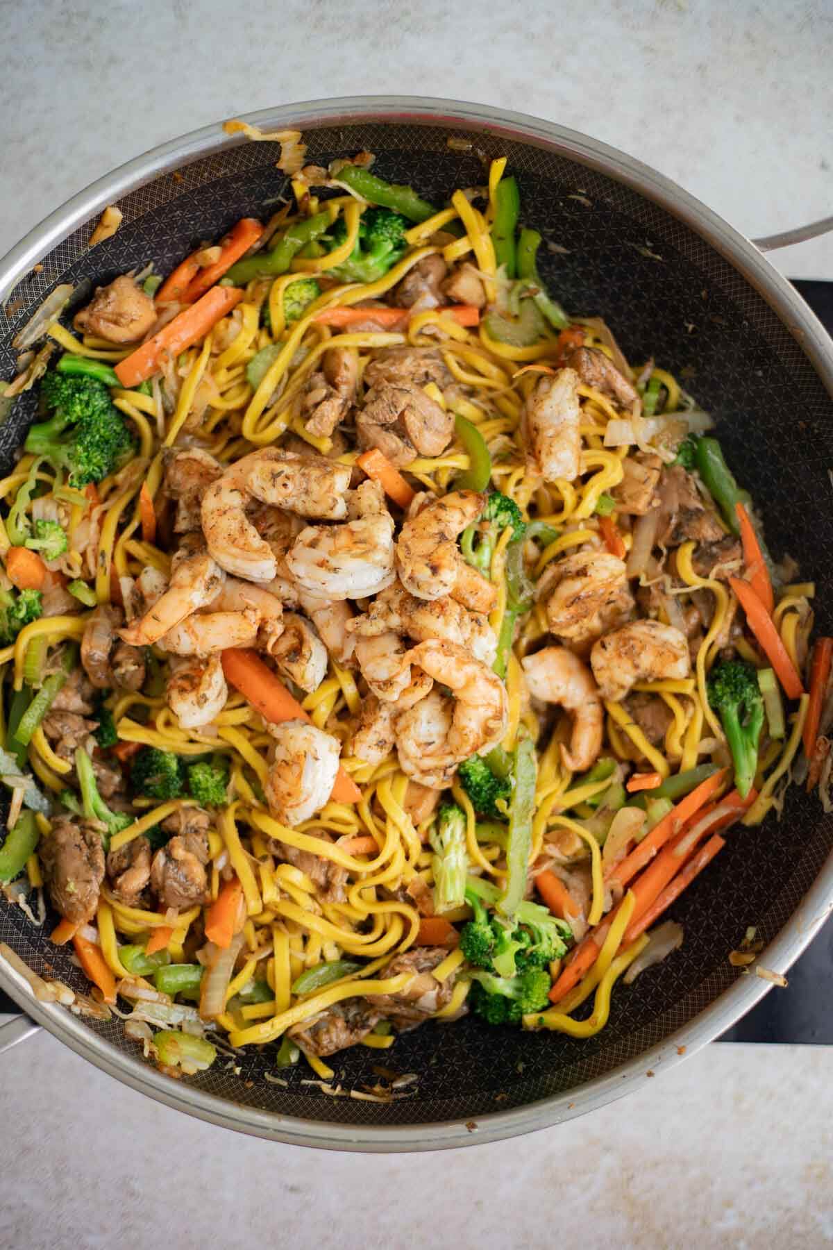 Cooked shrimp added to chicken and vegetable chow mein