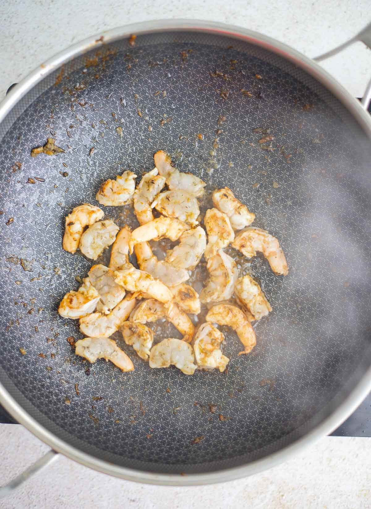 Seasoned shrimp cooking in a pan for Caribbean chow mein