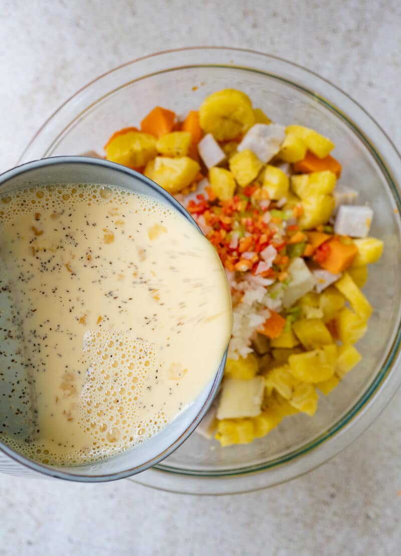 pouring milk and egg mixture over chopped ground provisions