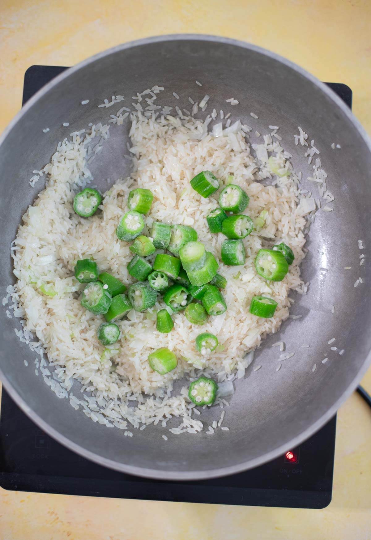 Frozen ochro added to rice and aromatics