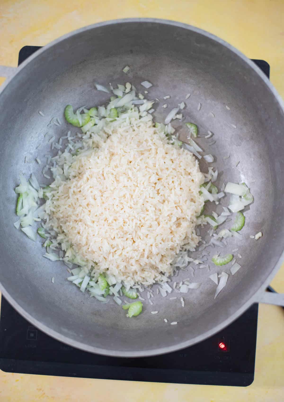 Parboiled rice added to sautéed onion, garlic and celery
