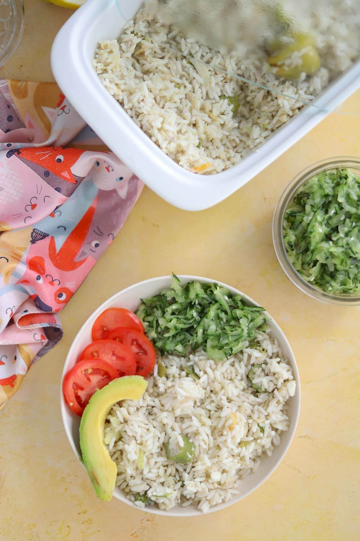 Stovetop saltfish and rice cook-up served with cucumber salad, tomato and avocado