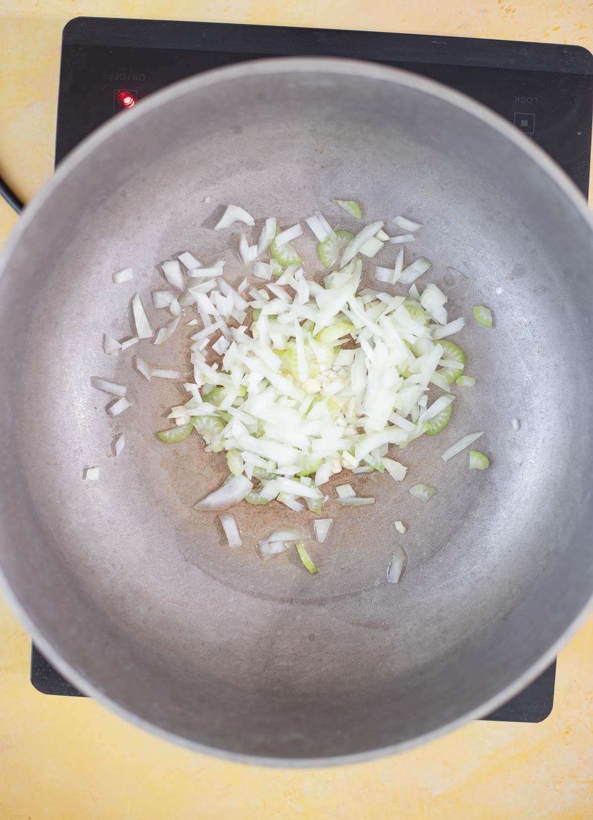Onion, garlic and celery sautéing in a pot
