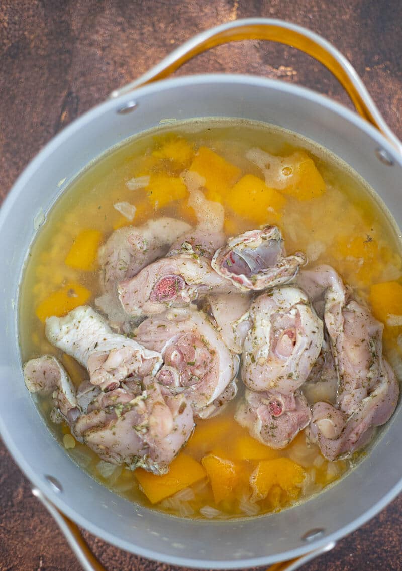 Seasoned chicken pieces added to the pot with softened pumpkin and split peas.