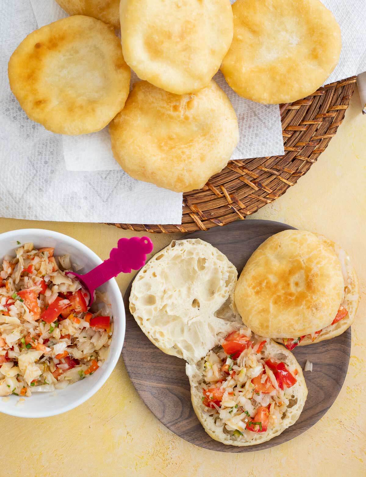 Saltfish buljol on top of fry bake on a white background.