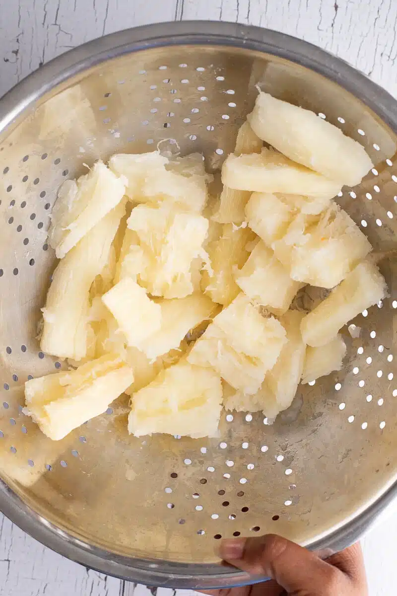 Boiled cassava draining in a colander