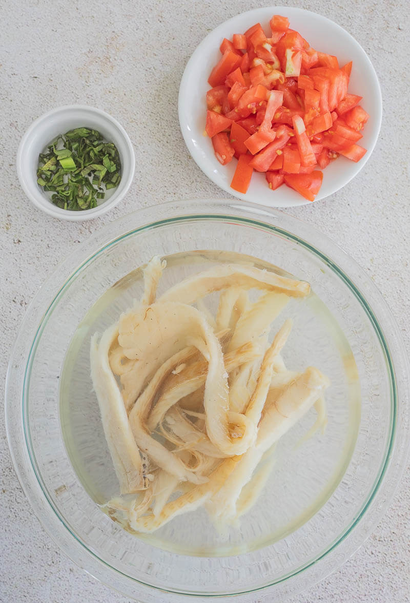 Salted cod soaking in water to remove excess salt and rehydrate.