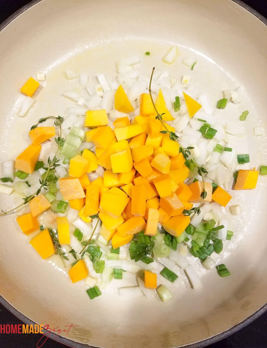 Sauteing of pumpkin, onion, thyme, garlic and pepper in butter