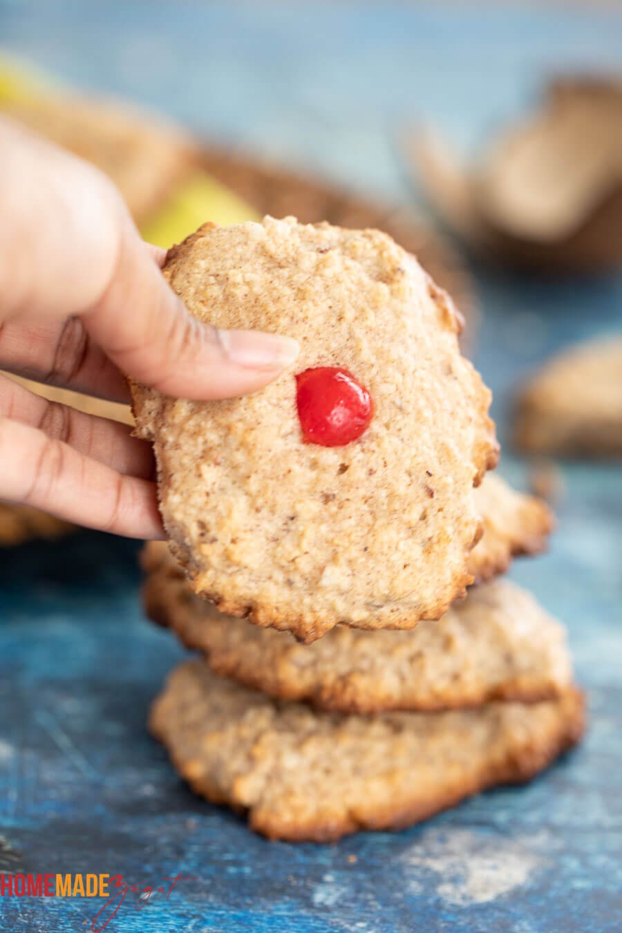 A picture of a hand holding one coconut drop with a cherry