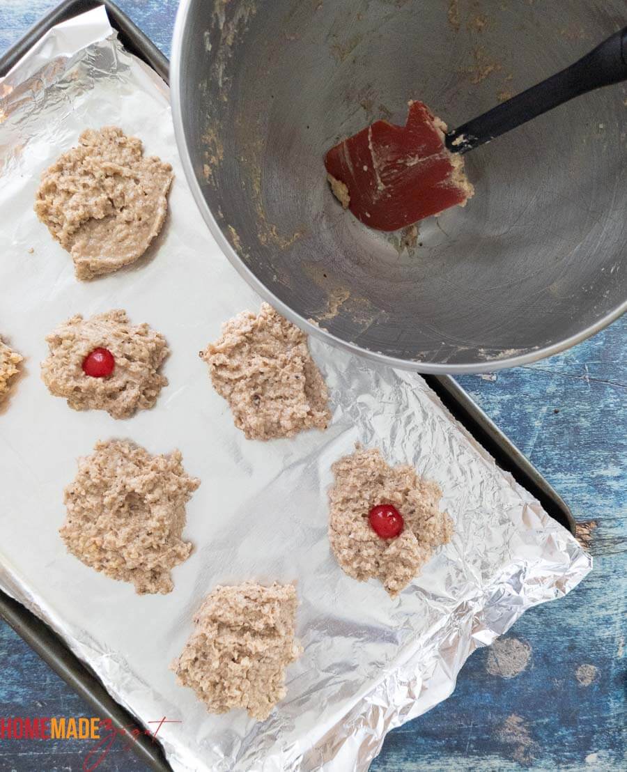 Batter for coconut drops being portioned out on a greased tray
