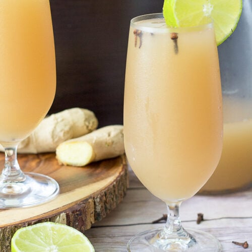 A tall, chilled glass of ginger beer with a slice of lime