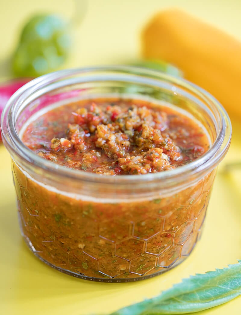 A close up of a jar of pepper sauce to see the chunky consistency.