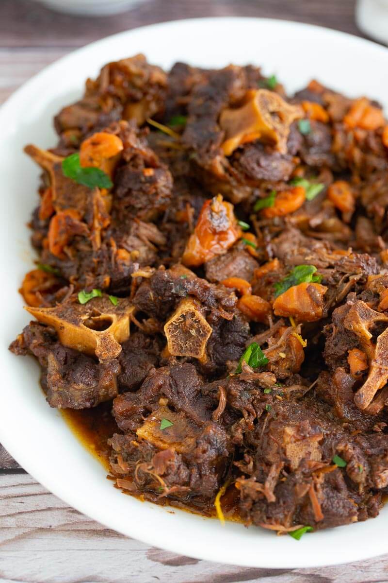 Straight on picture of a large plate of oxtail stew trini style