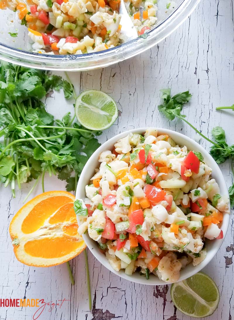 A large bowl of conch salad and a small white serving bowl filled with salad