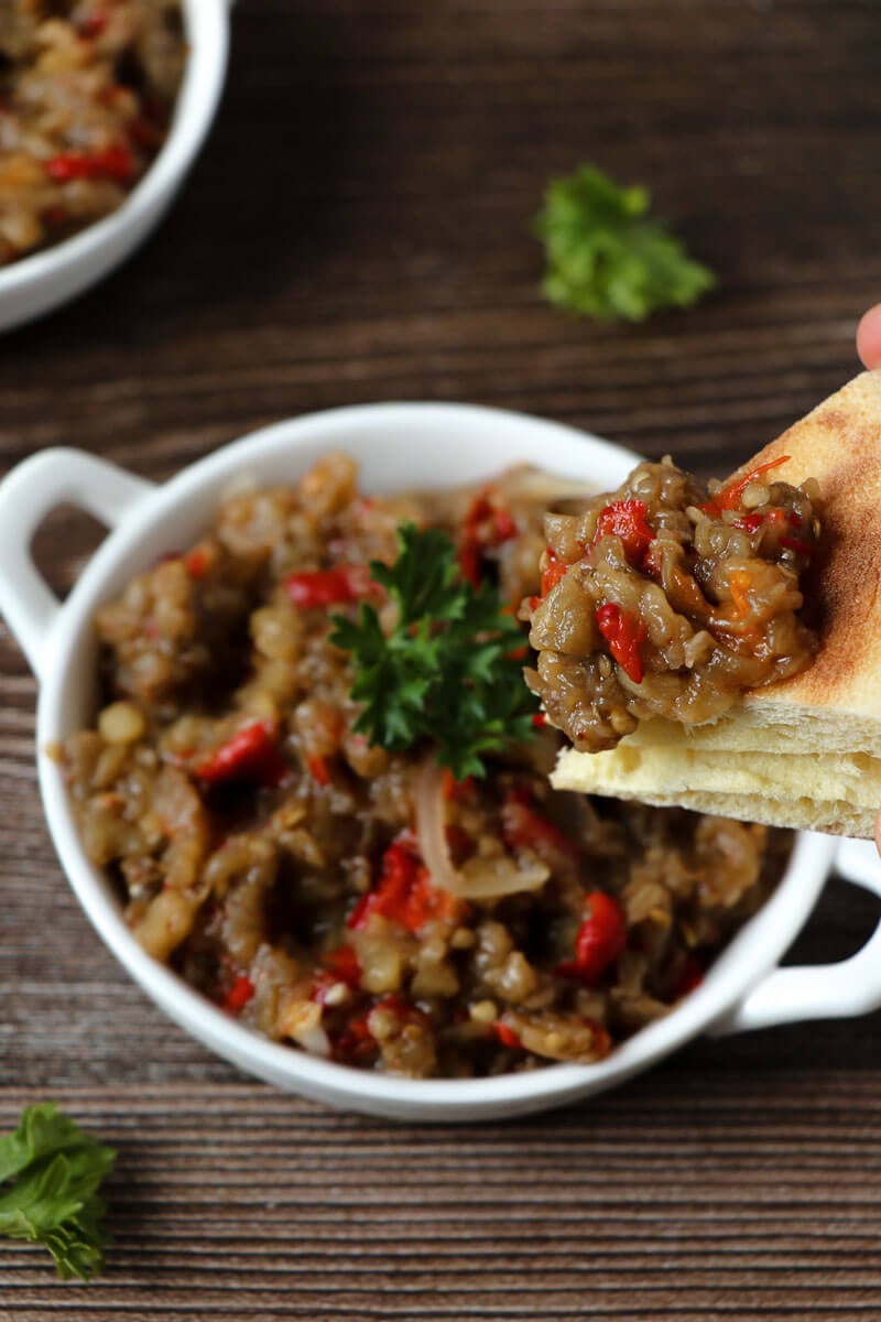 A dipping of bread with baigan choka on top.