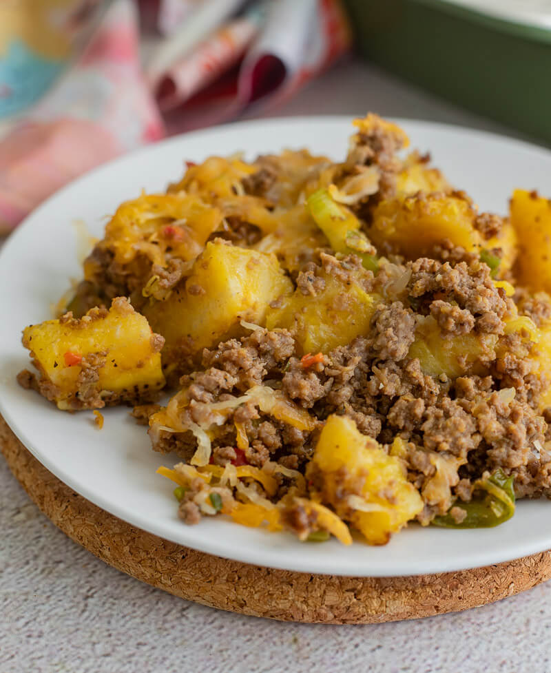 A white plate of plantain salad shared out.