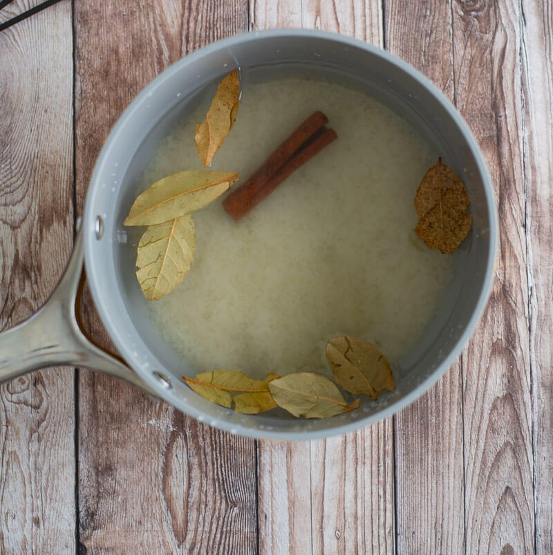 Water, rice, and spices in a deep pot to be put on the stove to boil.