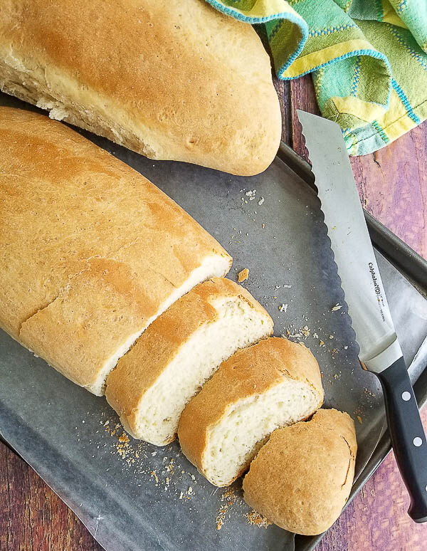 An overhead shot of a loaf of butter bread with some slices/