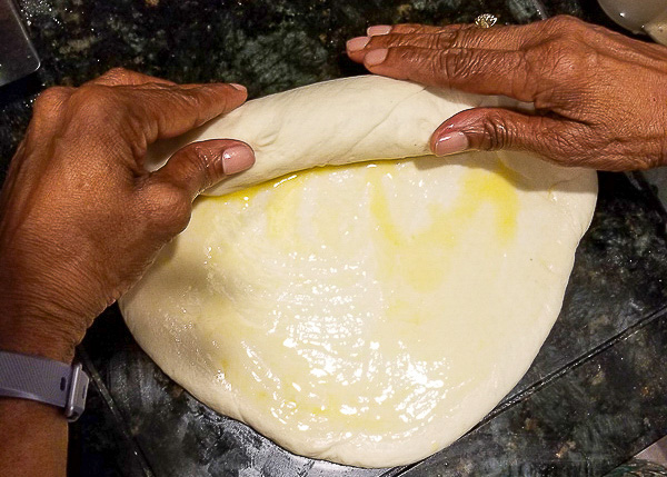Dough of bread being rolled up into a loaf.