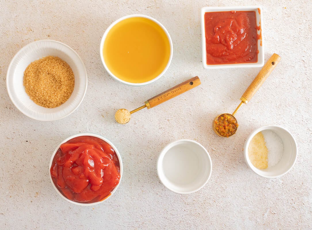 Ingredients needed to make this Caribbean bbq sauce shared out into amounts on a white counter top.