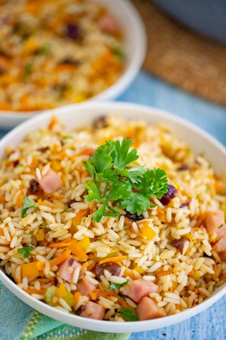 A bowl full of Christmas Rice garnished with a bustle of parsley.