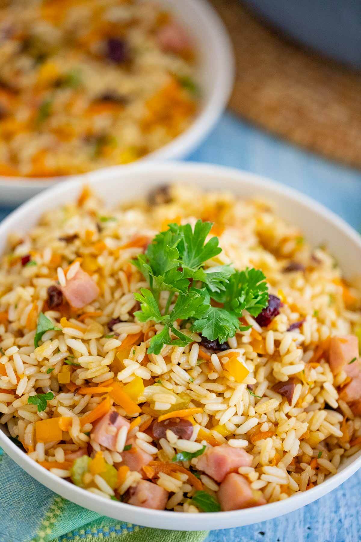 A bowl full of Christmas Rice garnished with a bustle of parsley.