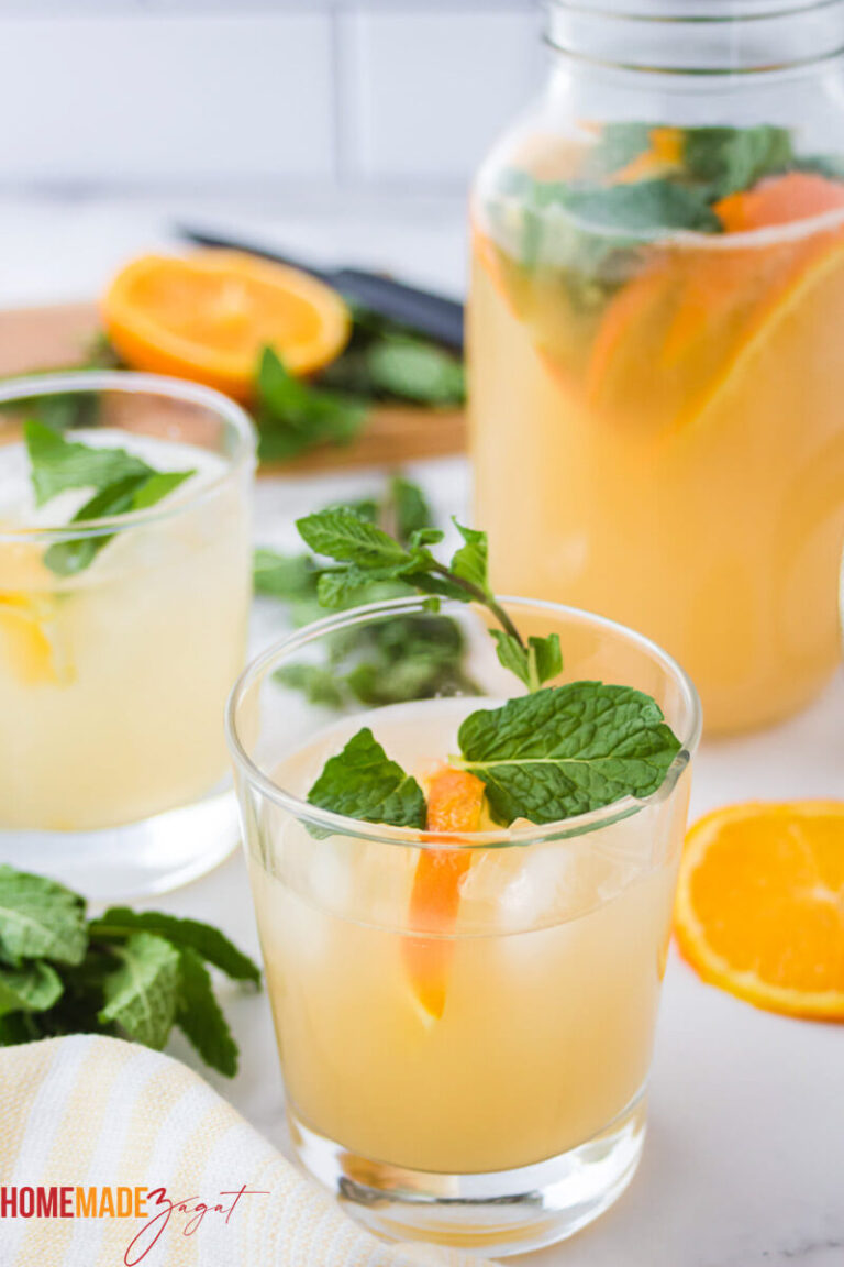 Glass of punch with mint and oranges as garnishes