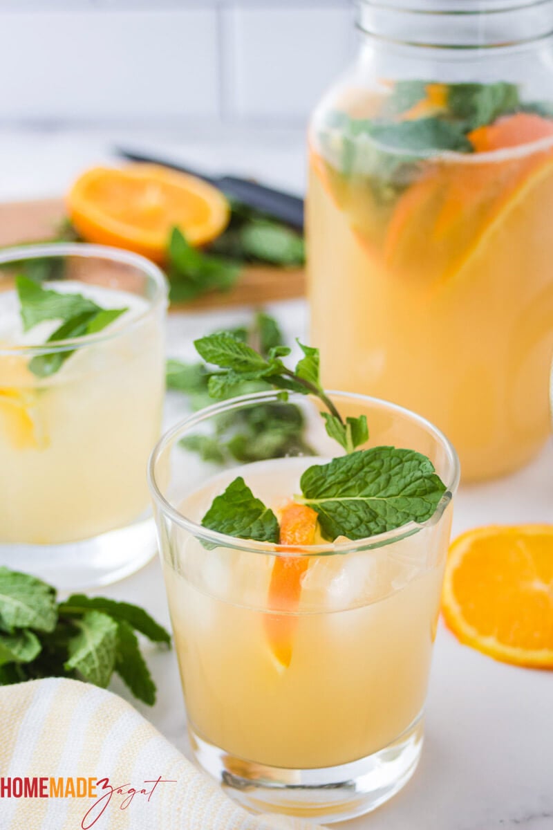 Mason jar of non alcoholic Caribbean punch with mint and oranges as garnishes