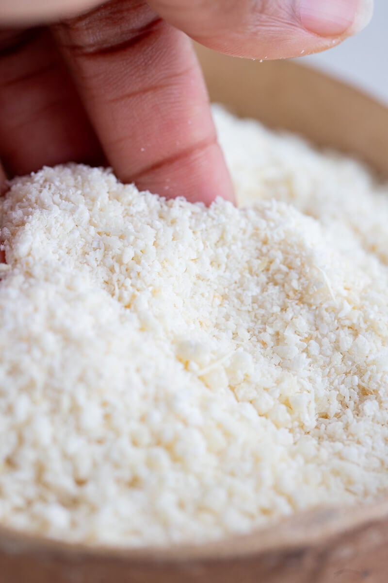 Coarse grains of farine being touched in the calabash.