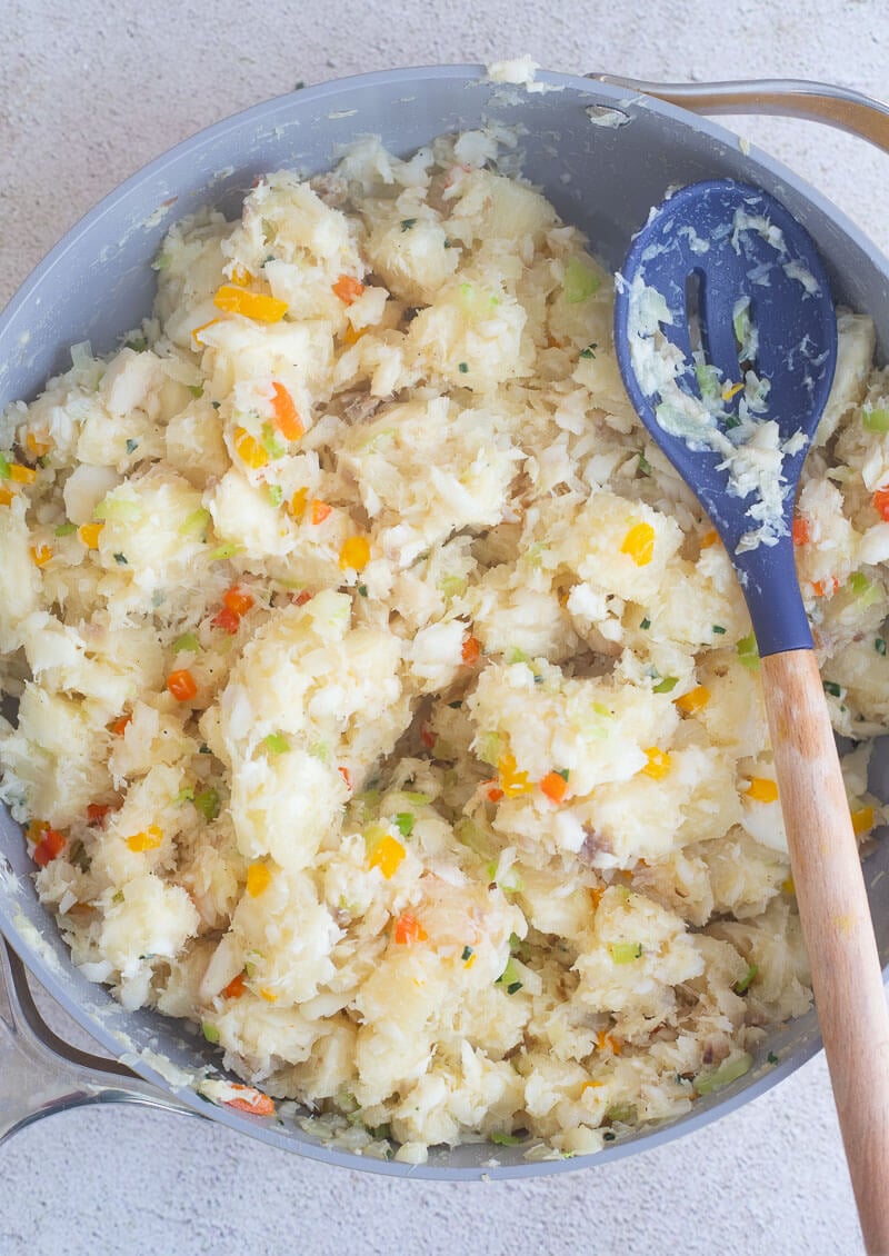 Combined boiled cassava and fish with aromatics in pot.