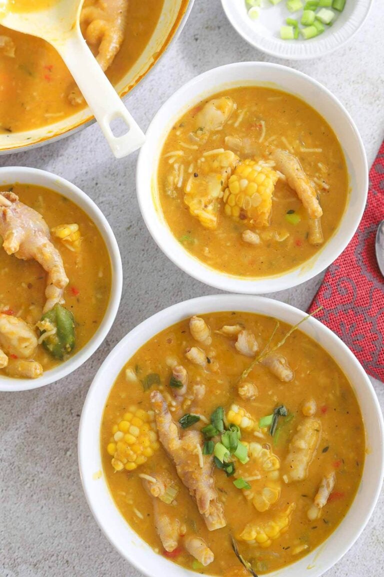 Multiple white bowls of chicken foot soup.