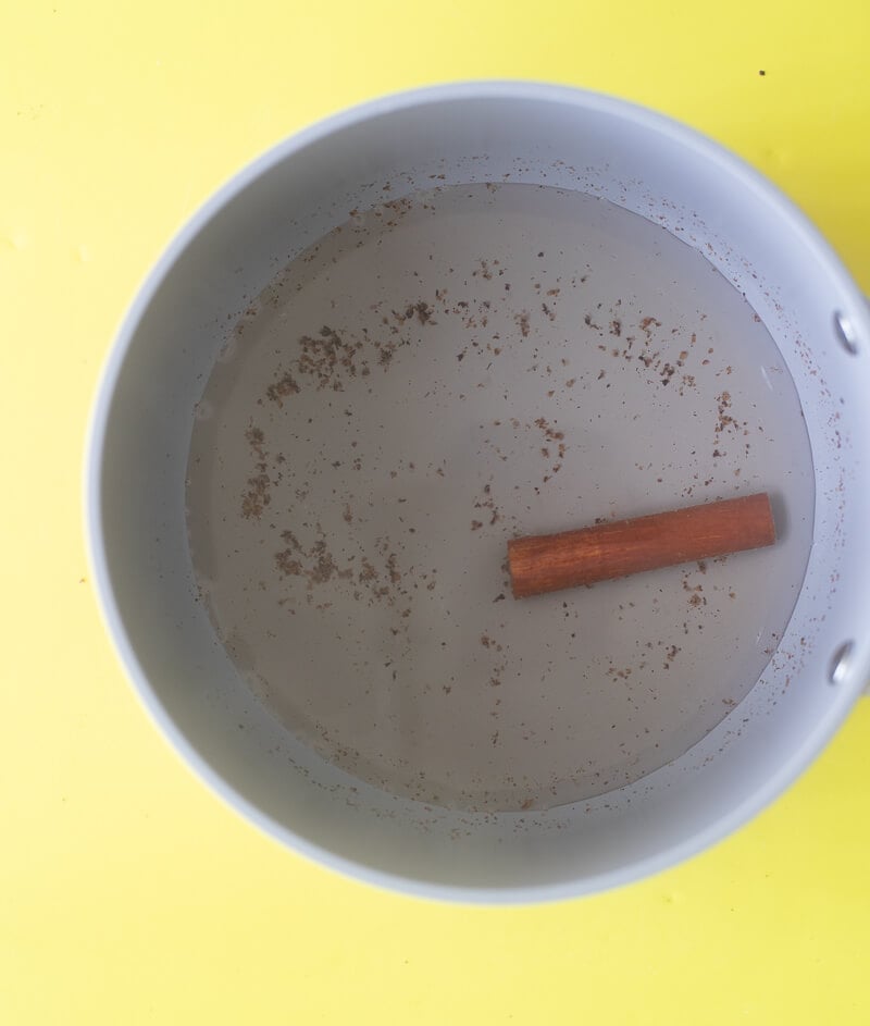 Water boiling with spices of nutmeg, cinnamon and salt to make cocoa tea.
