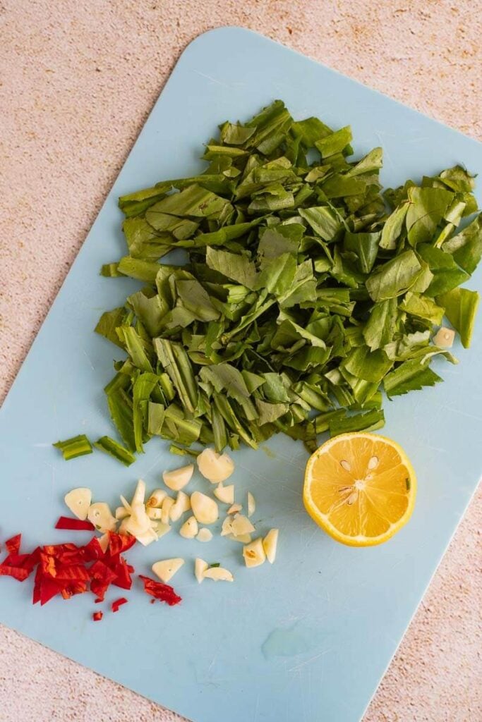 Chopped up ingredients on a blue cutting board.