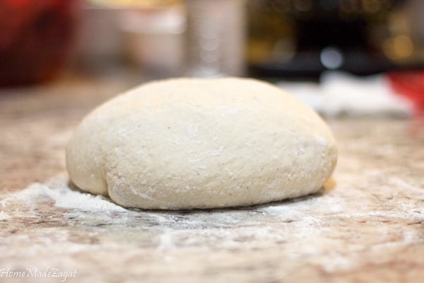 Mixed dough of coconut bake sitting on a floured counter top.