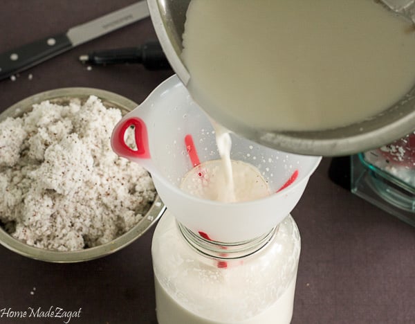 Straining coconut milk into bottle
