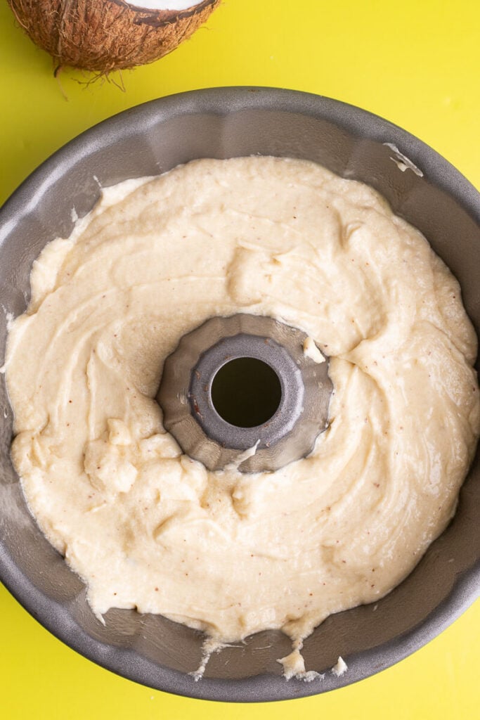 Coconut cake batter in a tubed bundt pan ready to be baked.