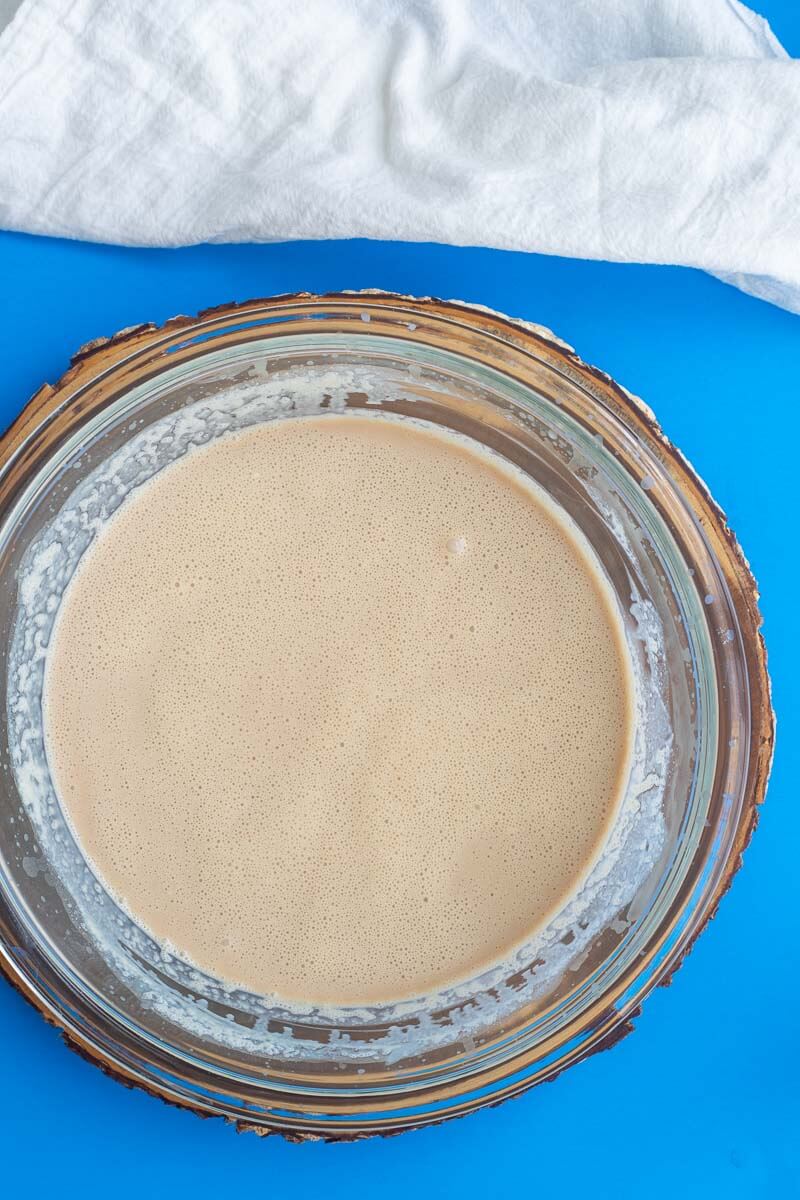 Combined rum cream ingredients in a shallow bowl on top of a blue counter.
