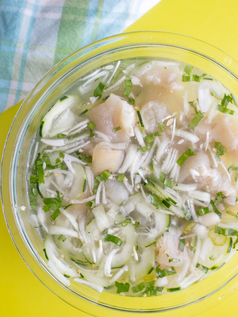 A finished bowl of souse one a yellow background.