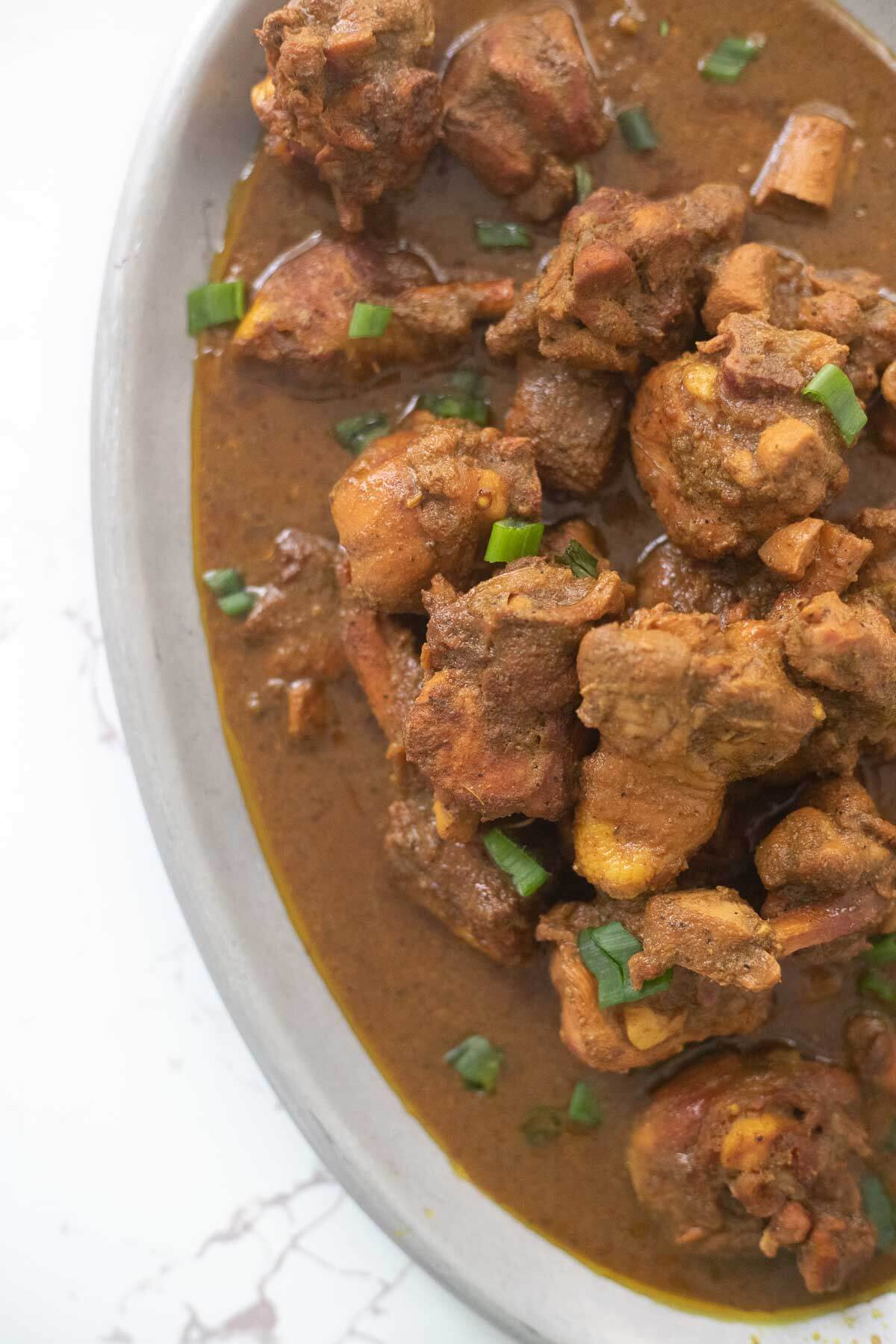 Top view of some curry stew chicken on a silver plate.
